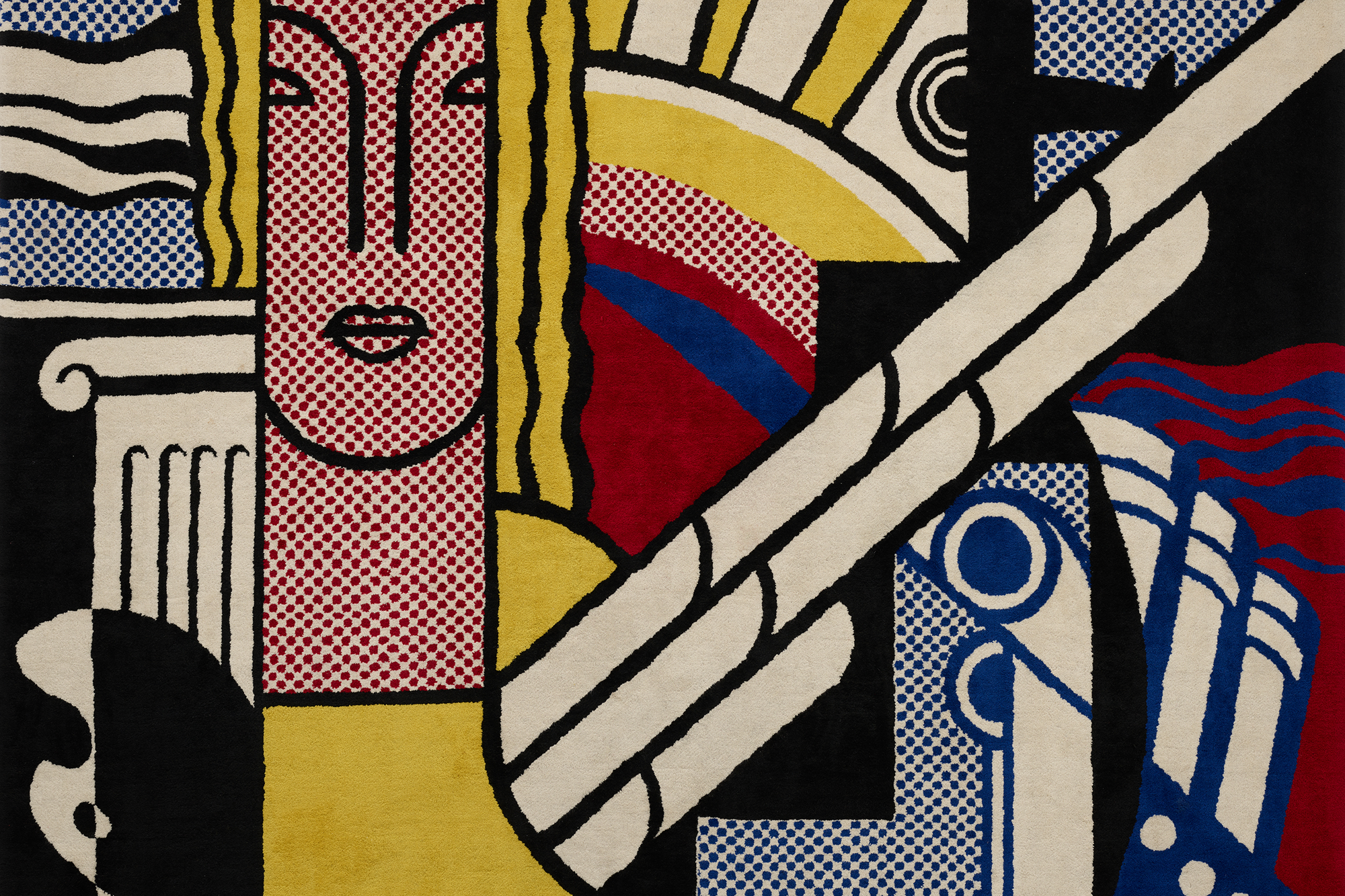 Gewobener Teppich mit graphischen Mustern, die ein weibliches Gesicht, die Sonne, Säulen und ein Boot darstellen.