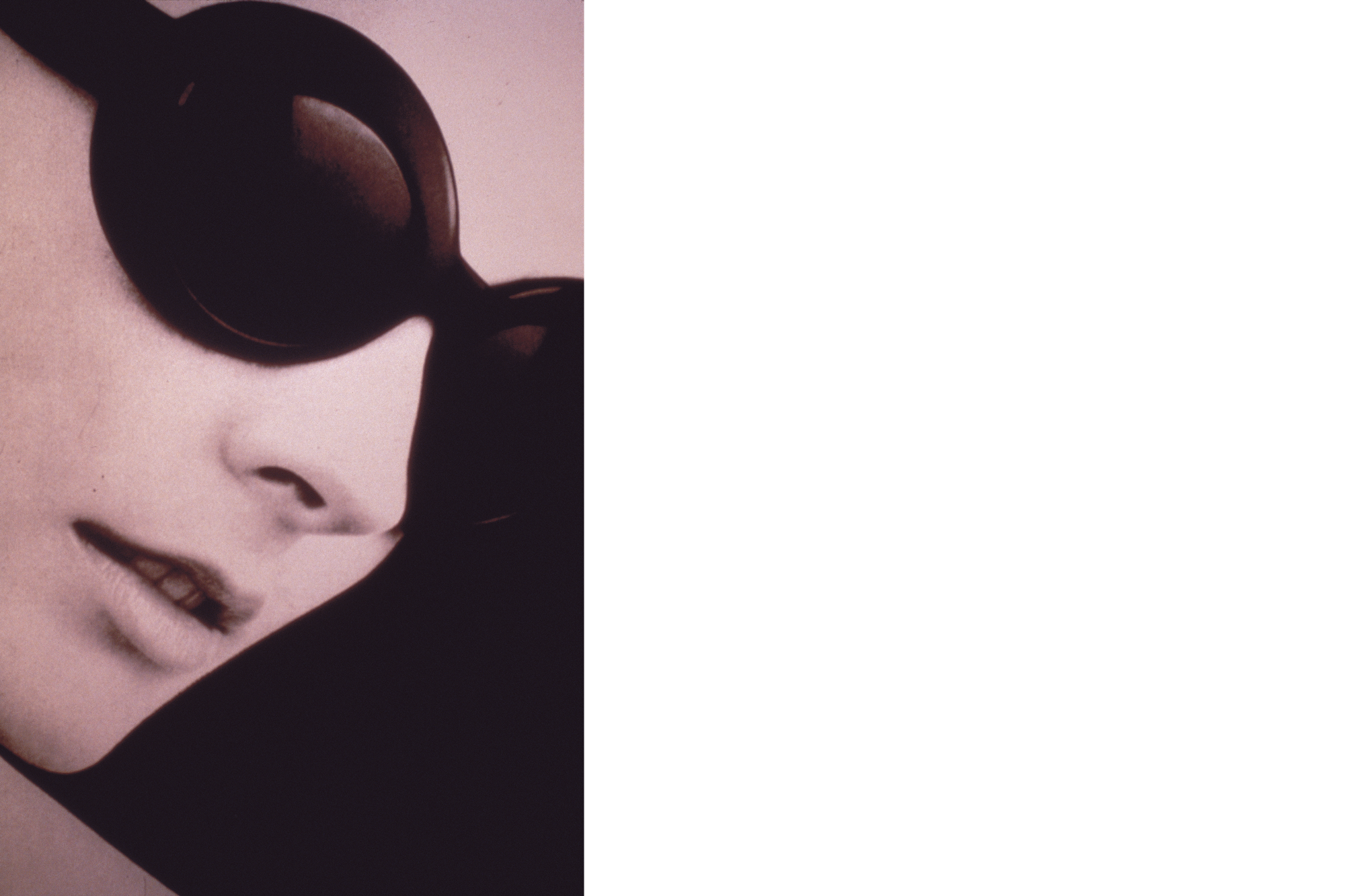 Schwarz-Weiß-Foto eines Frauenkopfes mit einer schwarzen Sonnenbrille.