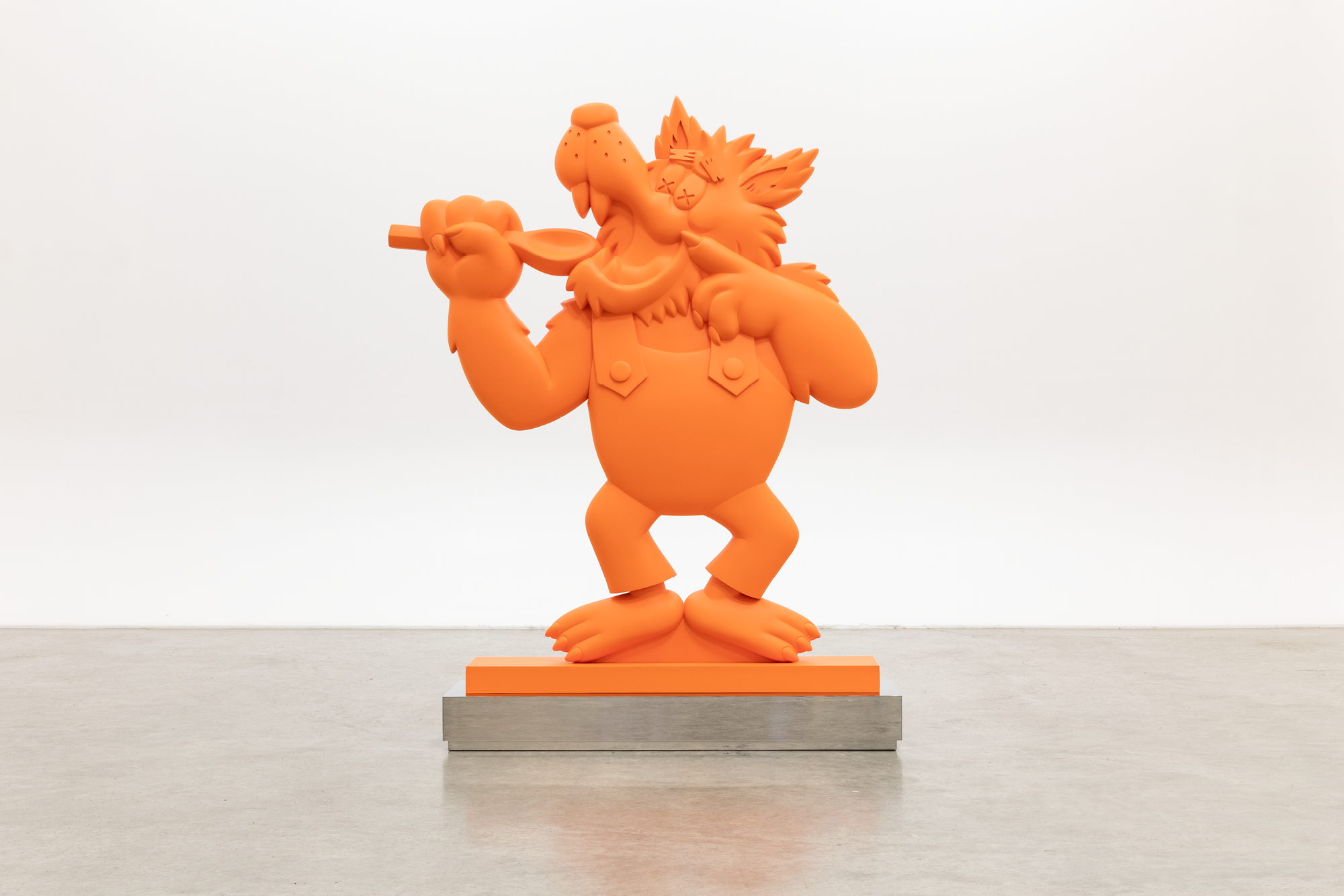 Eine orange Statue: Ein Comic-Wolf in einer Latzhose, der sich einen Löffel zum aufgerissenen Maul hält.