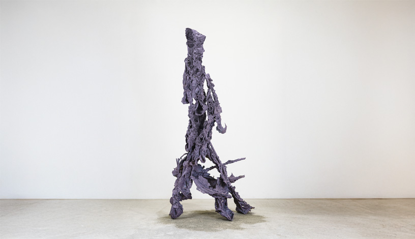 Eine abstrakte Figur, die aussieht wie ein Mensch, der mit seinem Hund spazieren geht.